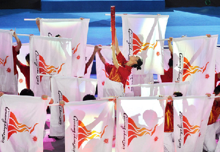 A dancer performs torch relay during a ceremony for the 100-day countdown to 16th Asian Games in Guangzhou, south China\s Guangdong Province, on August 4, 2010.